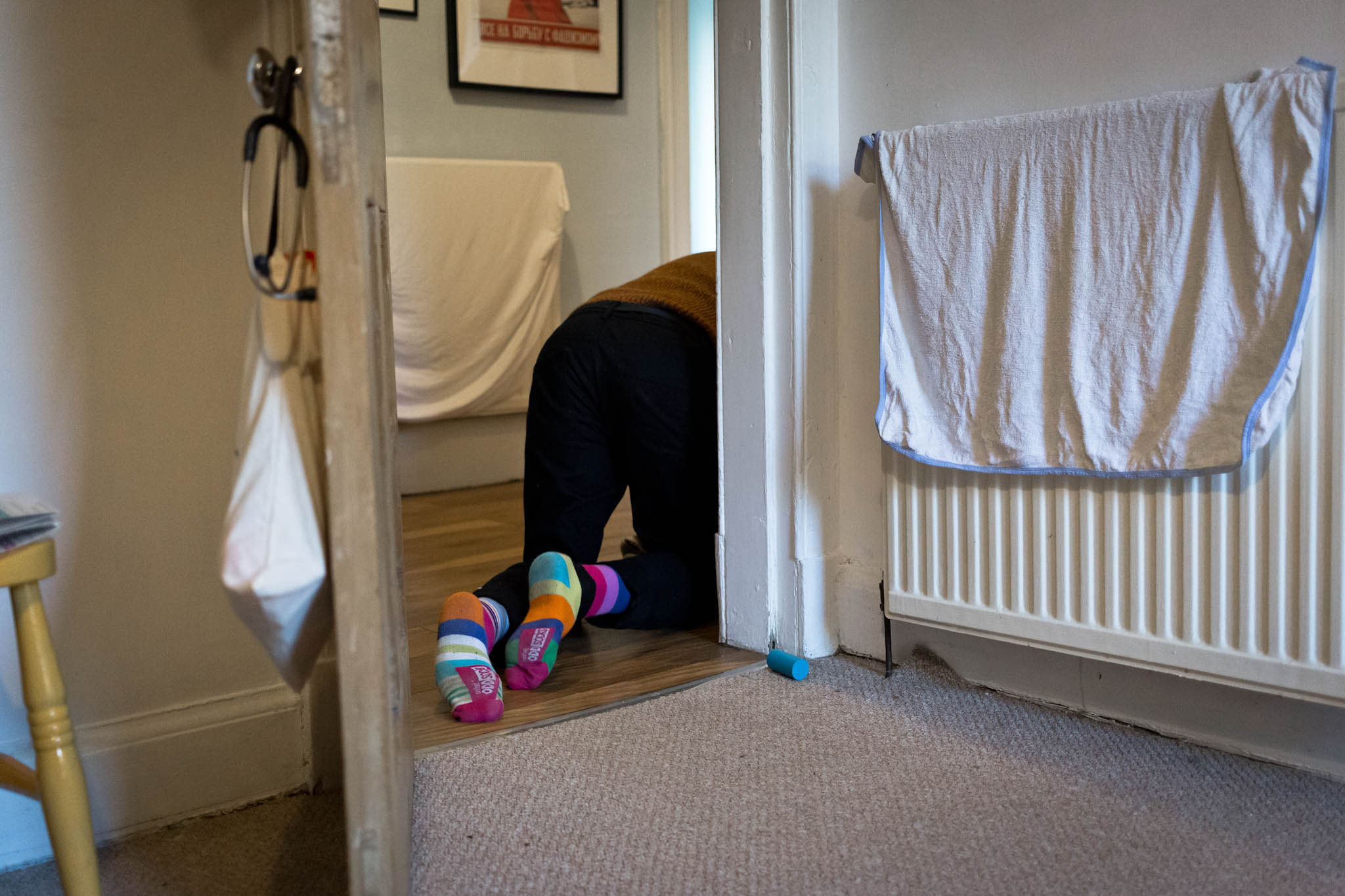 Feet in colourful socks seen crawling away through a doorway following baby